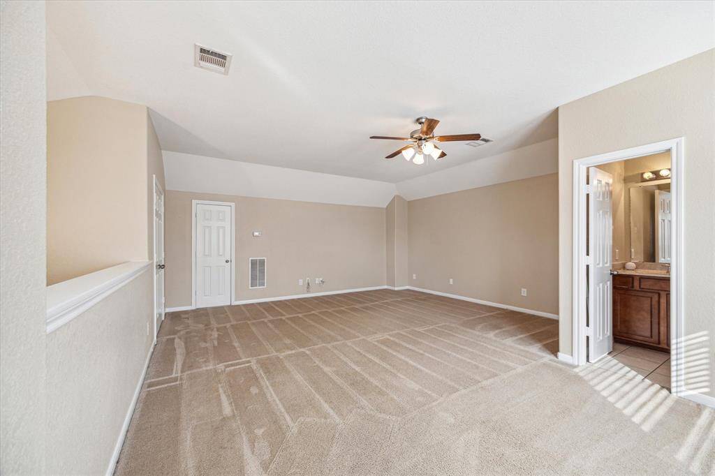 Versatile upstairs game room with additional storage and full bathroom.