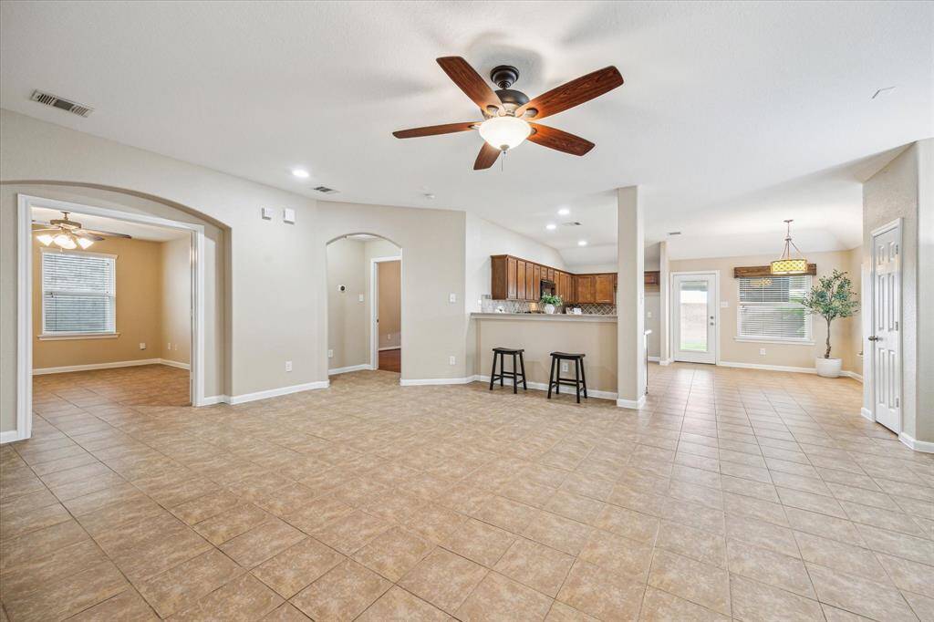 The spacious living room flows effortlessly into the kitchen and breakfast area, creating a bright, open-concept layout perfect for both entertaining and everyday living in this beautiful Tomball home.