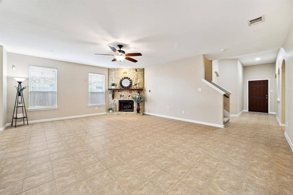 Spacious living area with high ceilings and a natural stone fireplace.