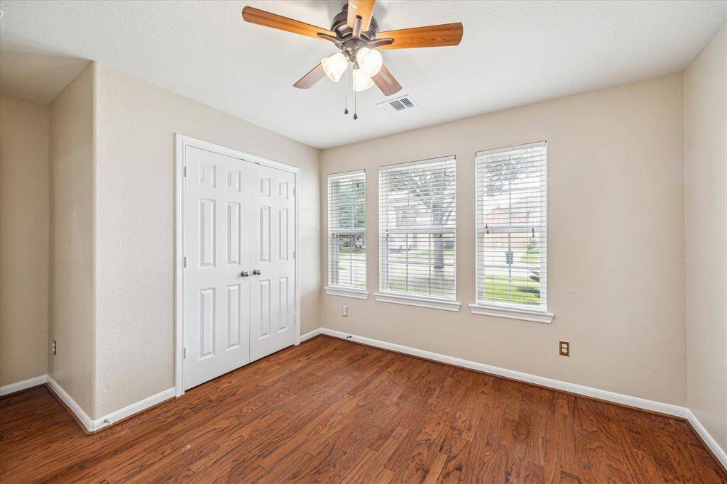 This secondary bedroom offers flexibility for a guest room, home office, or child’s room, featuring neutral tones and a welcoming layout in this well-appointed home.