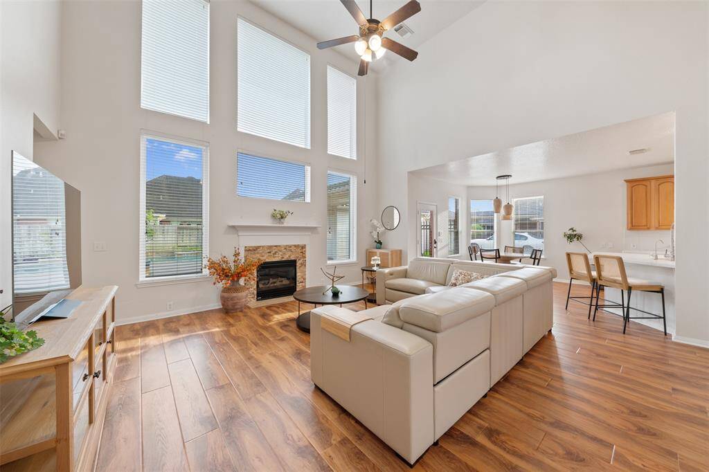 Living room with soaring ceilings, expansive windows, hardwood floors