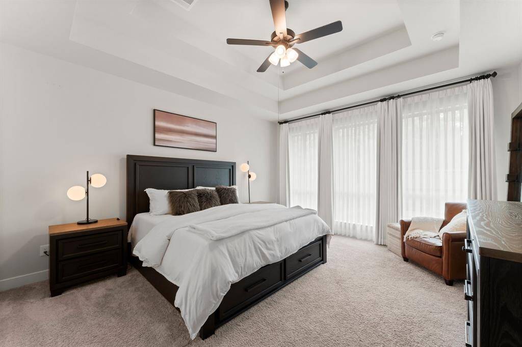 Primary retreat features double tray ceilings, bay windows, and ceiling fan.