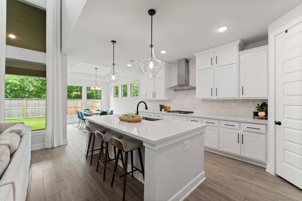 Kitchen boasts stainless steel appliances, quartz counters, and modern fixtures.