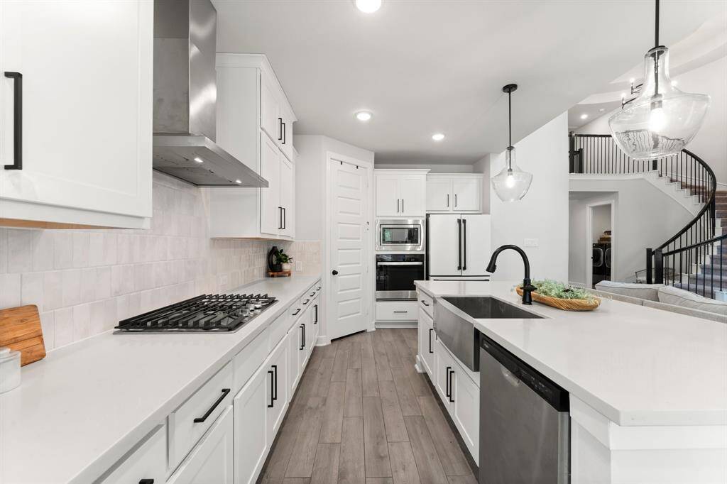 Large island with steel farmhouse sink is perfect for entertaining.