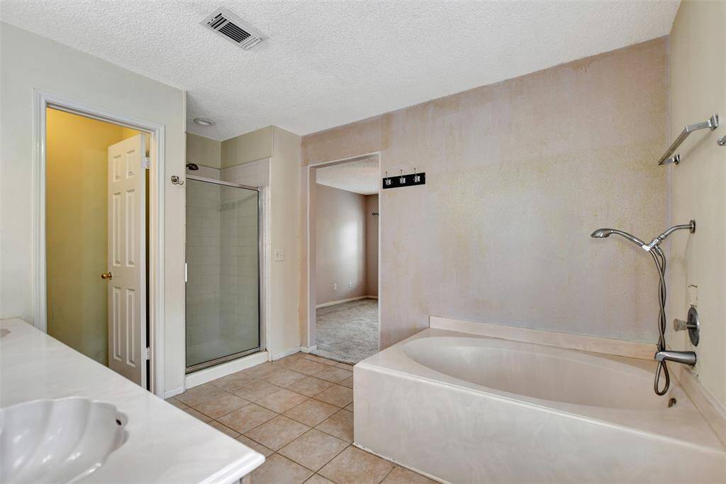 Spacious primary en-suite featuring a shower, garden tub, double sinks and large walk-in closet.
