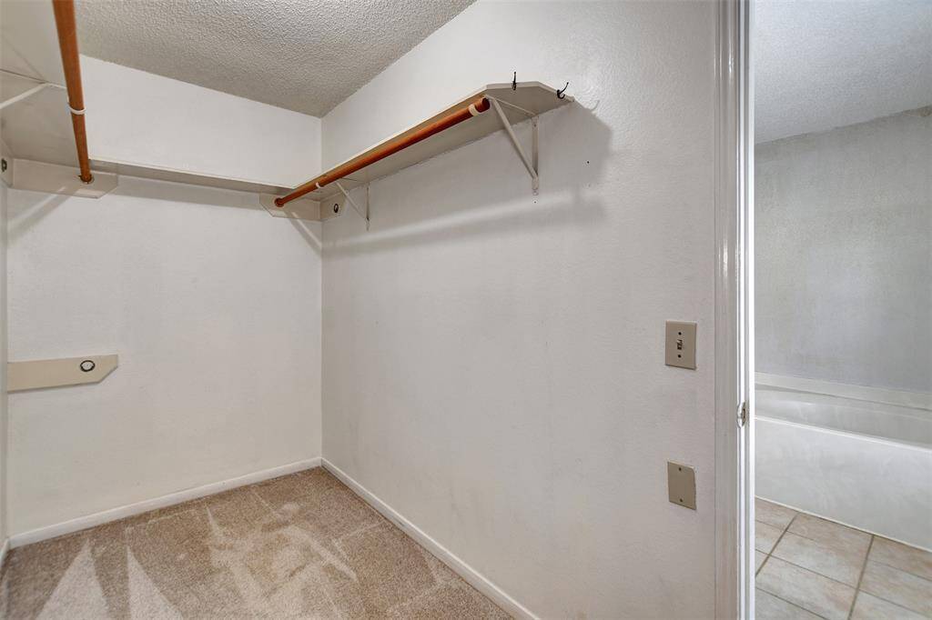 Walk-in closet has plenty of space for your hanging clothes and even shelving for accessories.