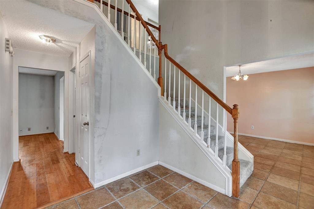 Photo shows dining area, foyer, hallway where under stairs storage and half bath are located.
