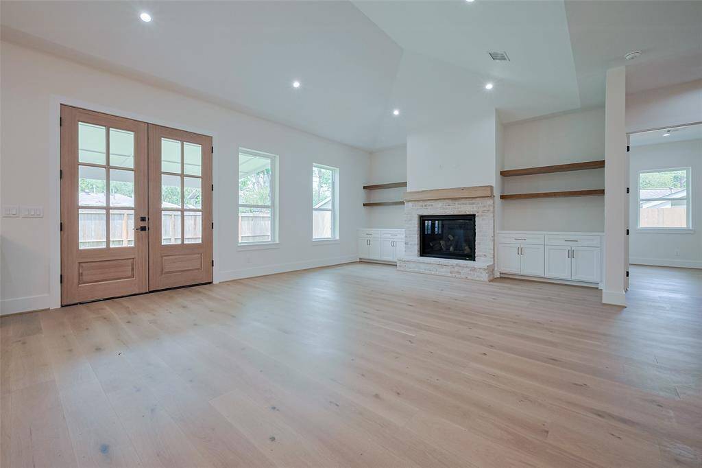 Living room with vaulted ceilings and open floor plan showcase 8'ft mahogany doors and gas f/p