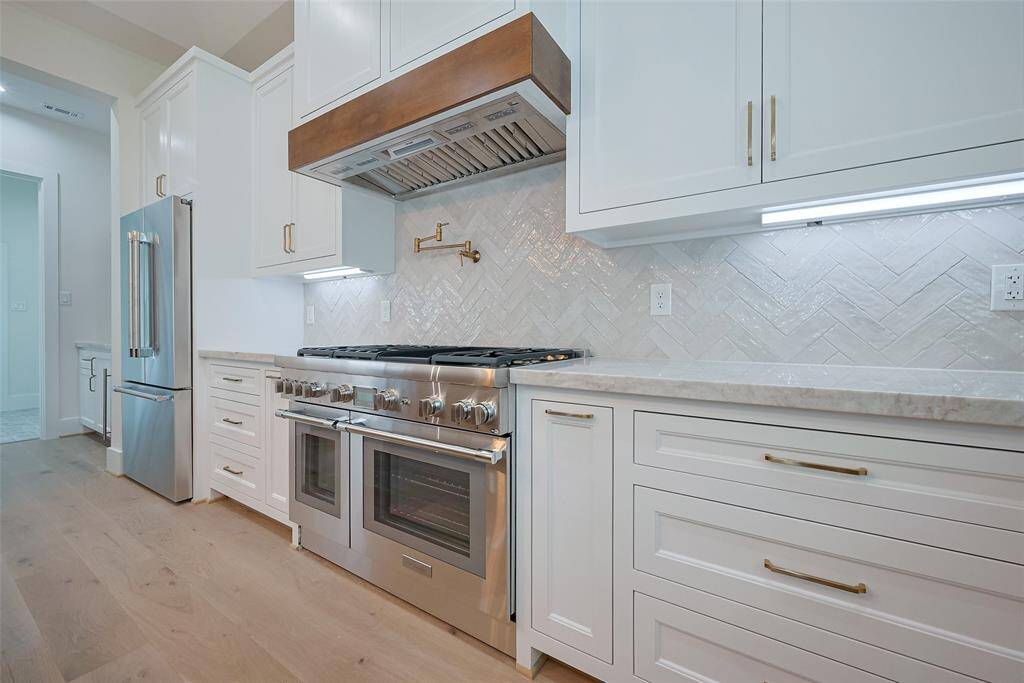 48" range and pot filler are focal features to this chef's kitchen
