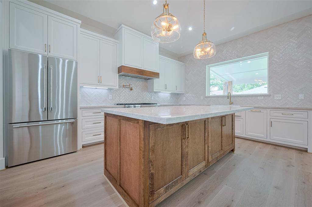 Taj Mahal-Quartzite countertops and pendent lights add a bright setting