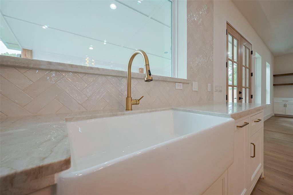 Apron sink and antique gold fixture are elegant