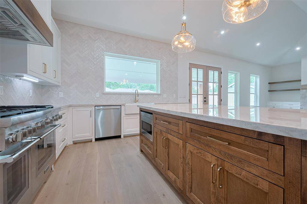 Kitchen-oversized picturesque window is surrounded with tile all the way to ceiling