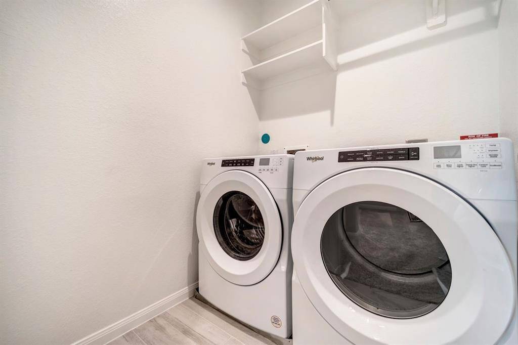 Spacious laundry room on the second floor with built-in shelves and hanging space.