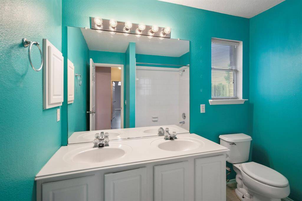 The secondary bath with dual sinks and a medicine cabinet, as well as under counter storage.