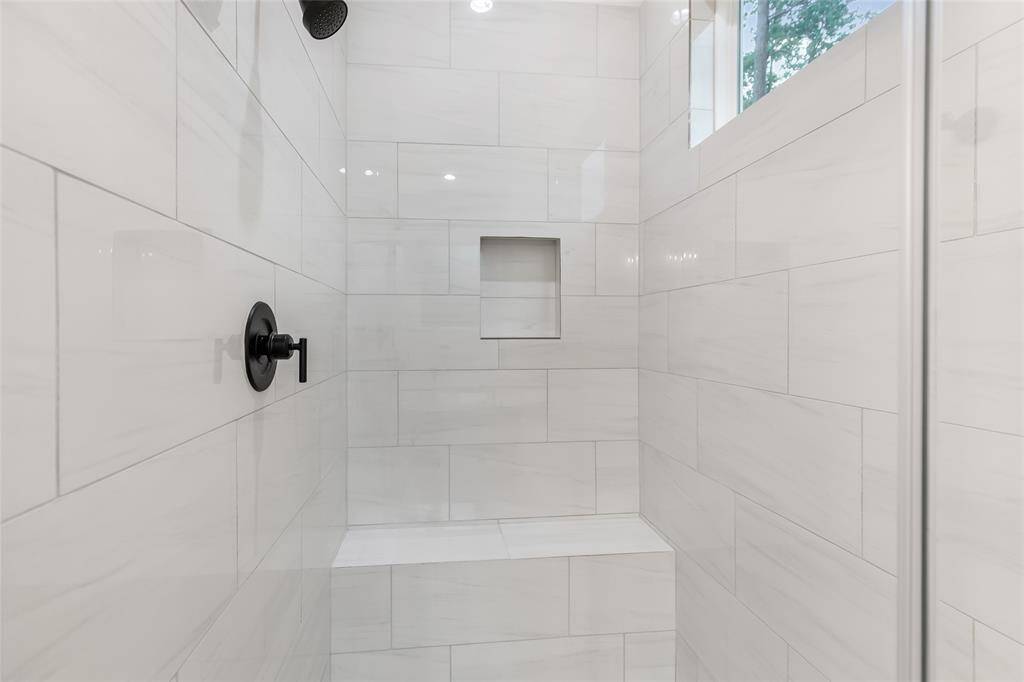 The primary bath offers a separate shower with a bench & multiple shower heads