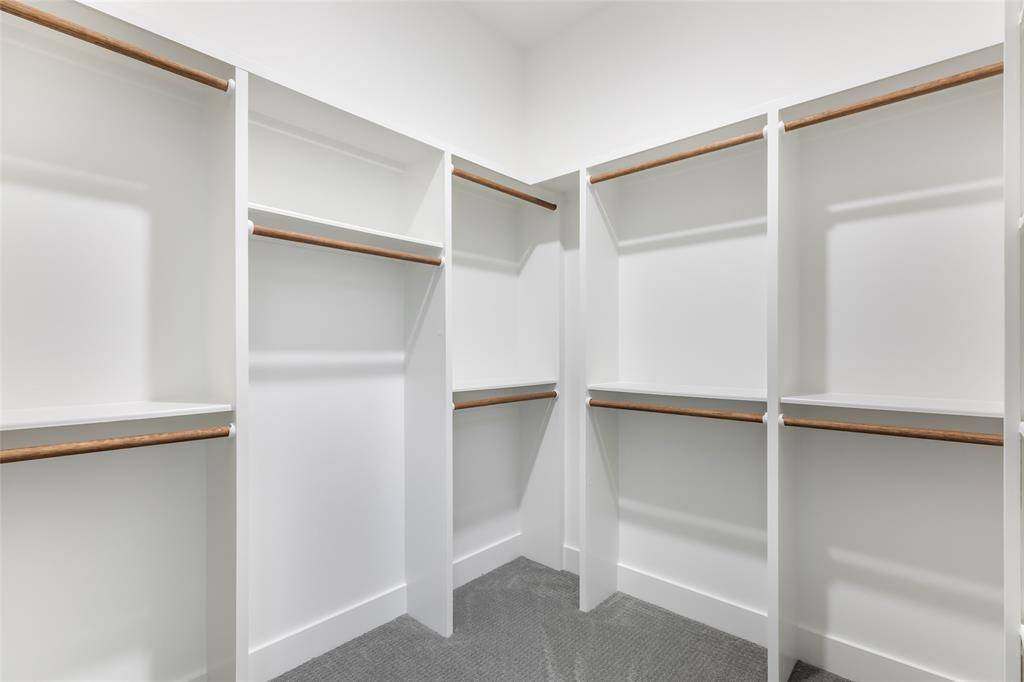 The primary closet offer multiple hanging rods and plenty of storage