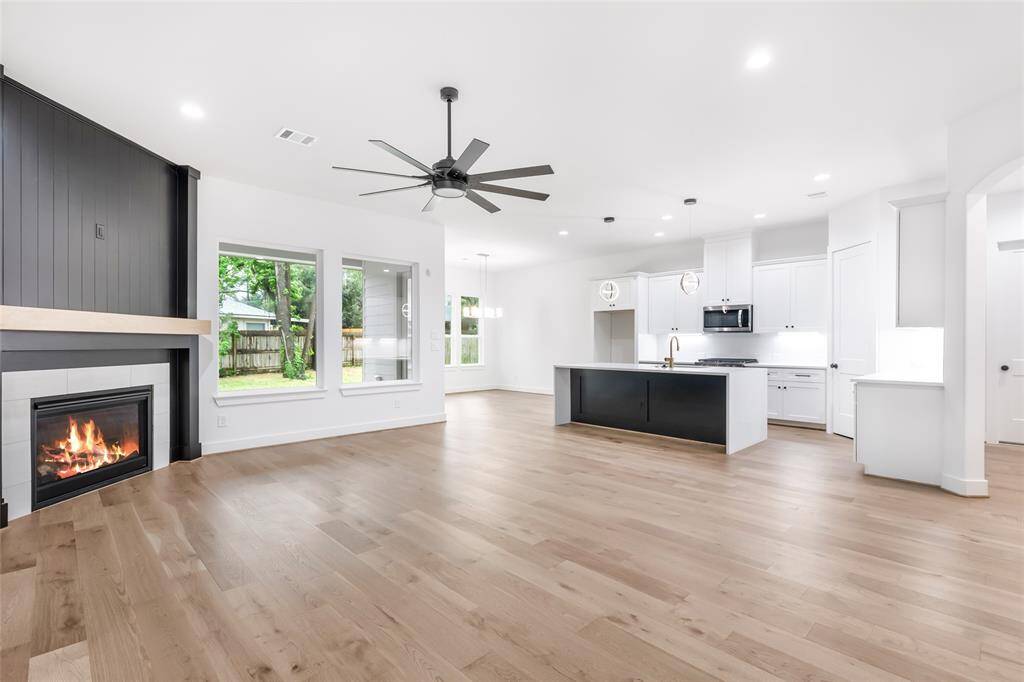 This spacious open-concept living area features a modern kitchen with a large island, sleek cabinetry, and stainless steel appliances.