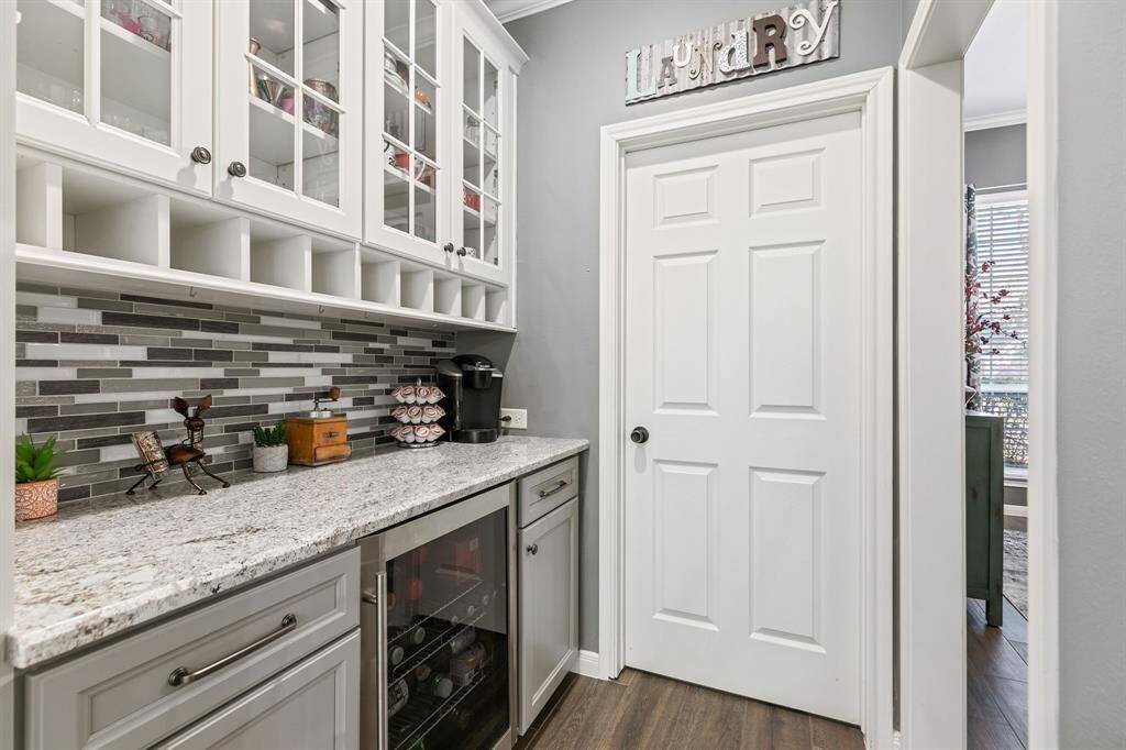 The granite kitchen is a chef's delight, showcasing a stylish tile back-splash & modern appliances, including butlers pantry and beverage cooler.