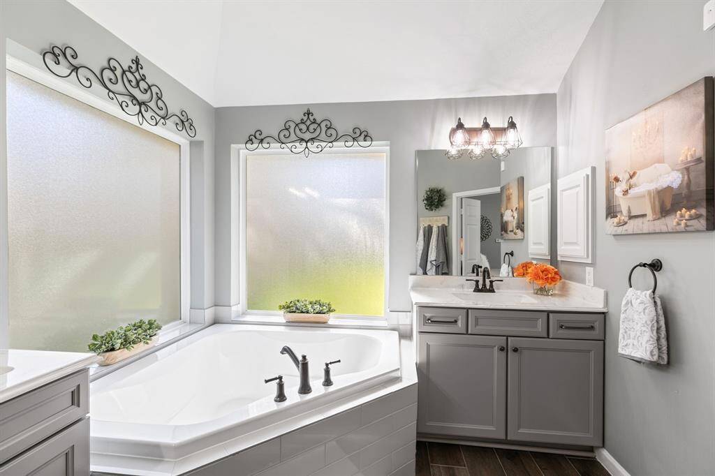 You will be pampered in a luxurious primary bathroom that features a corner bathtub and large walk in closet.