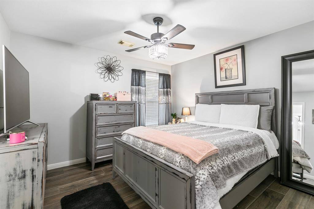This third bedroom features a ceiling fan, walk in closet and tile floors.