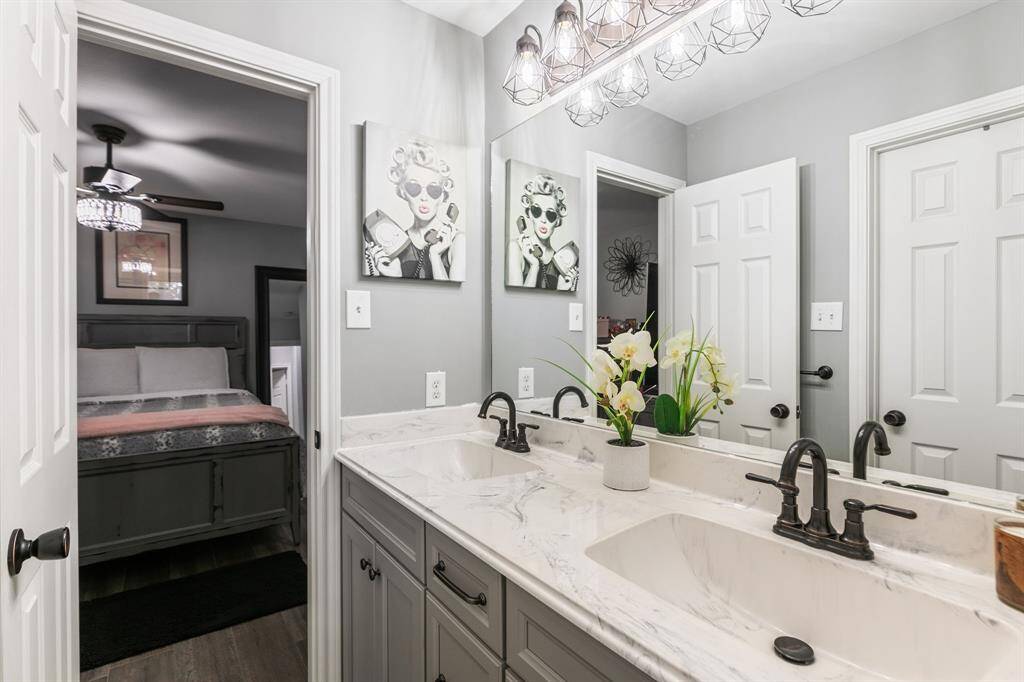 This bathrooms serves bedrooms three and four. It features dual sinks, a shower/tub combination and tile floors.