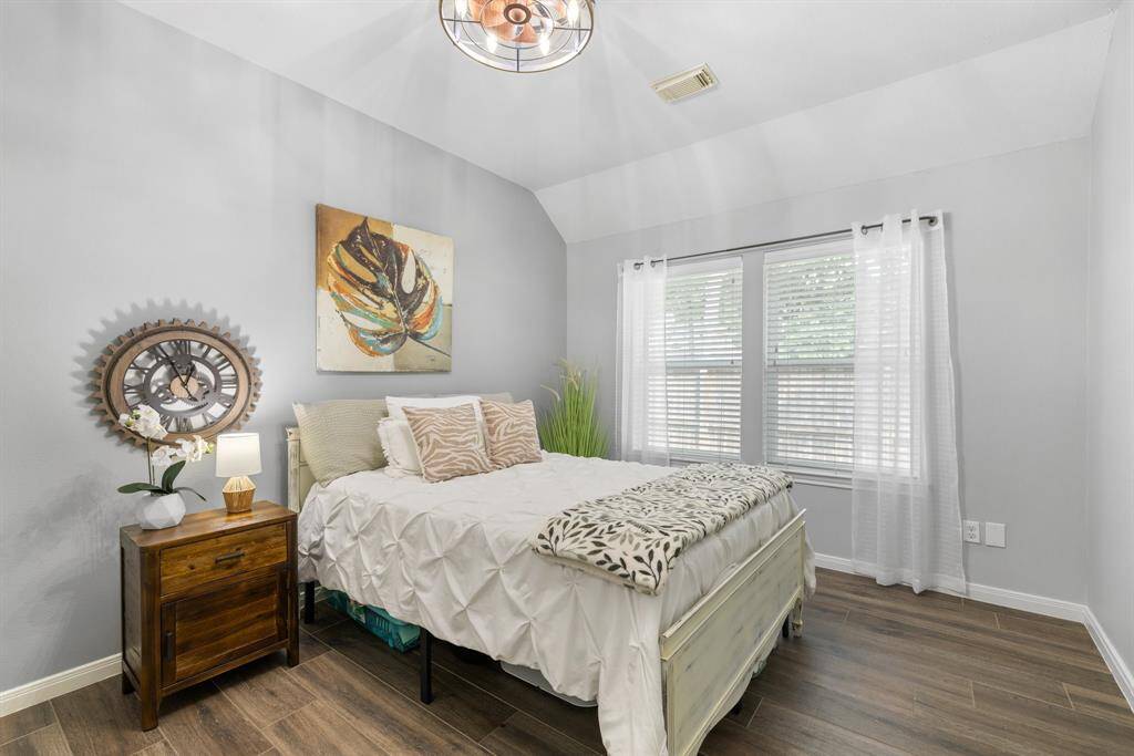 This fourth bedroom features a walk in closet, ceiling fan and tile floors.