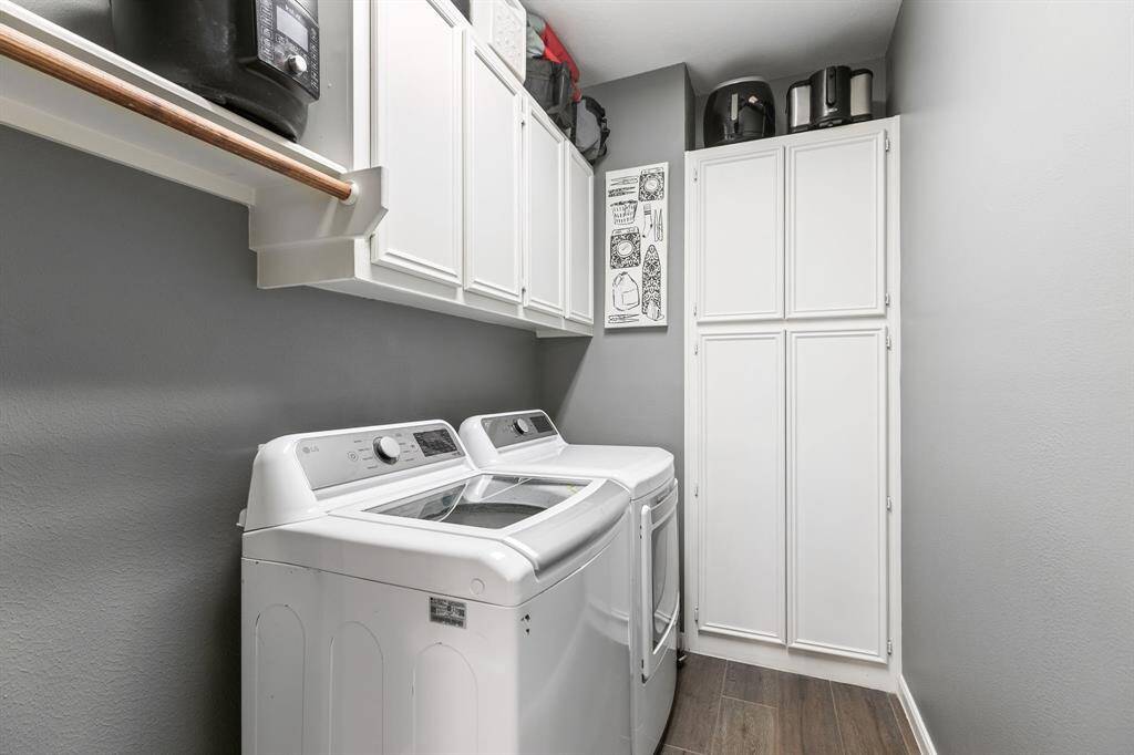The utility room has ample storage space. It offers upper cabinet space and a clothes hanging rod. Plus, room for a freezer.