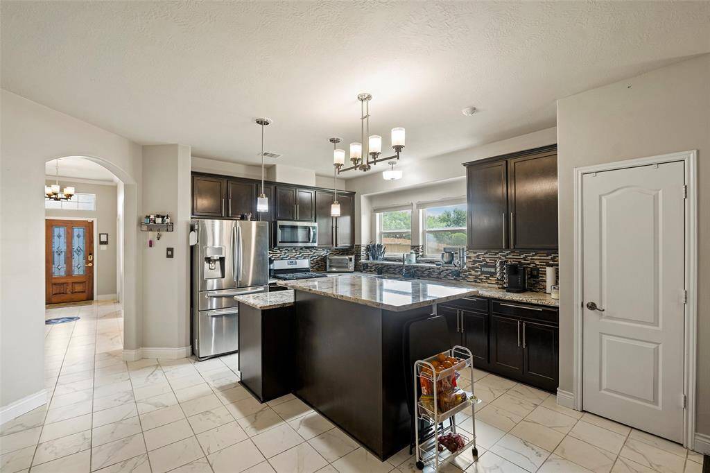 which has beautiful backsplash and enlarged kitchen island