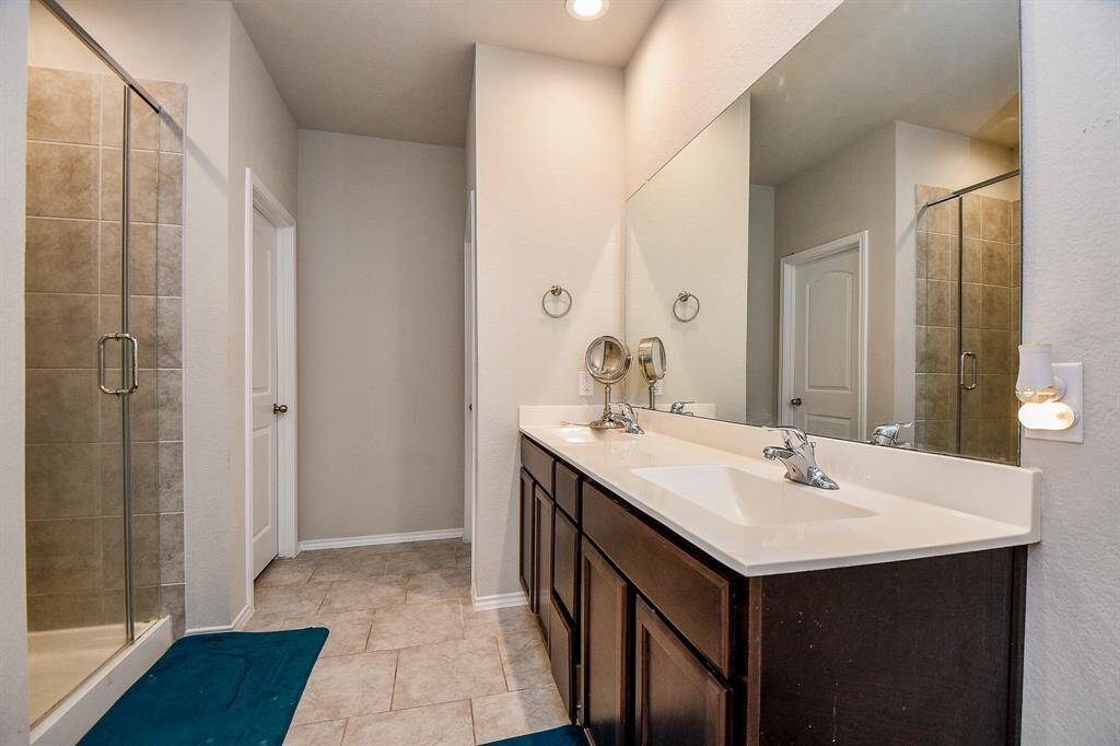 Double vanities and tiled glass shower with separate tub soaking tub.