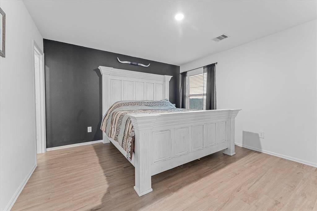 The primary bedroom is situated at the back of the house, offering privacy and tranquility. Conveniently located near the back door and kitchen, it provides easy access to the backyard while maintaining a peaceful retreat from the main living areas.