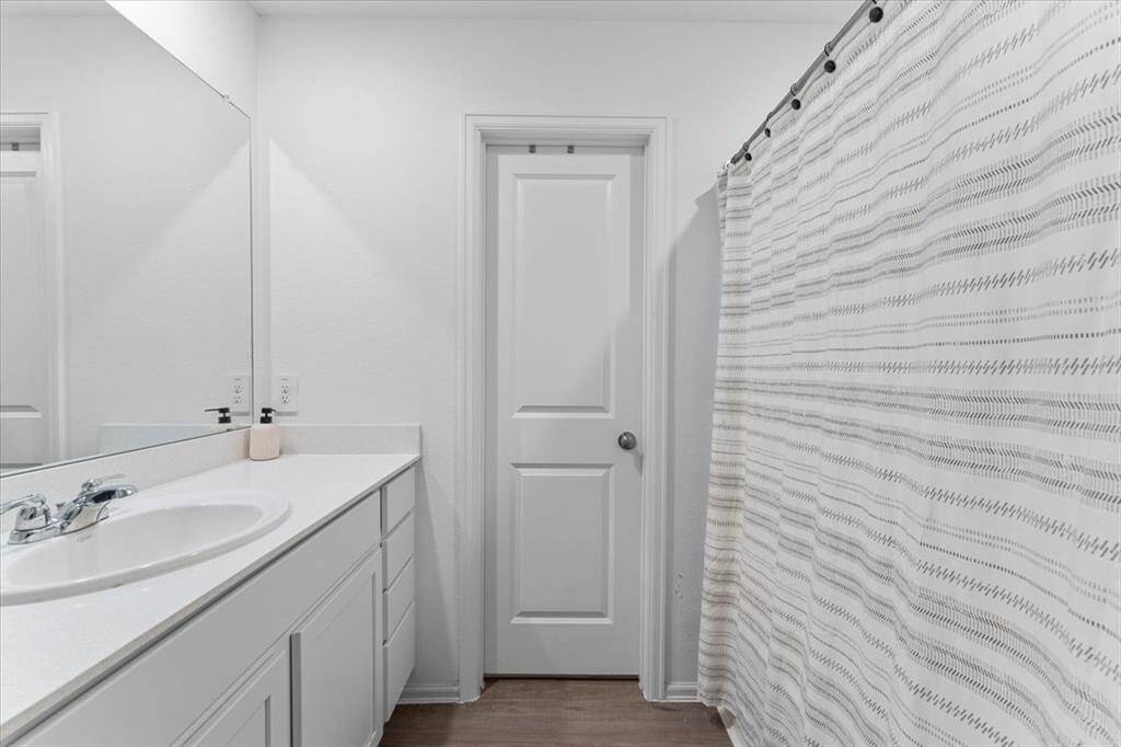 The primary bedroom is situated at the back of the house, offering privacy and tranquility. Conveniently located near the back door and kitchen, it provides easy access to the backyard while maintaining a peaceful retreat from the main living areas.
