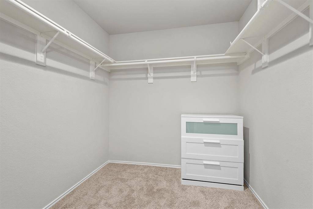 The large walk-in closet offers ample space for storing clothing, shoes, and accessories, with room to keep everything organized and within easy reach.