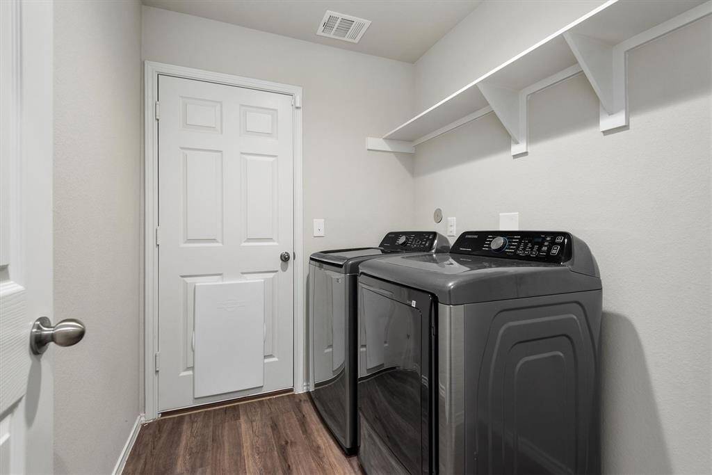 The laundry room includes a convenient shelf above the appliances, perfect for storing detergents and essentials. Plus, the washer and dryer are included.