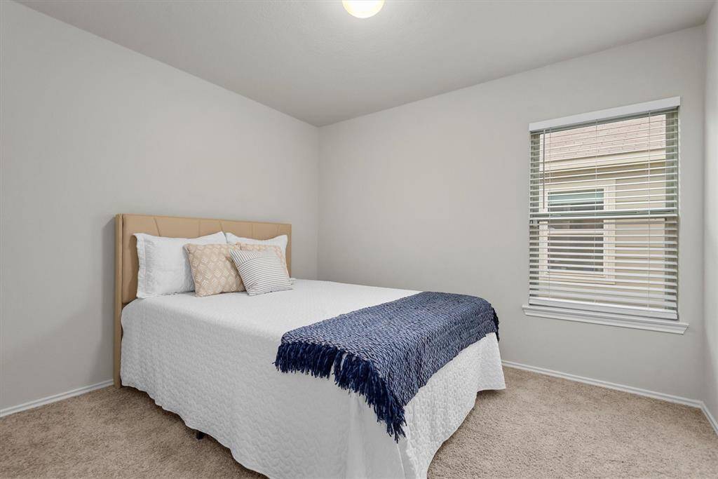 The first secondary bedroom is spacious and filled with natural light, offering a cozy atmosphere.