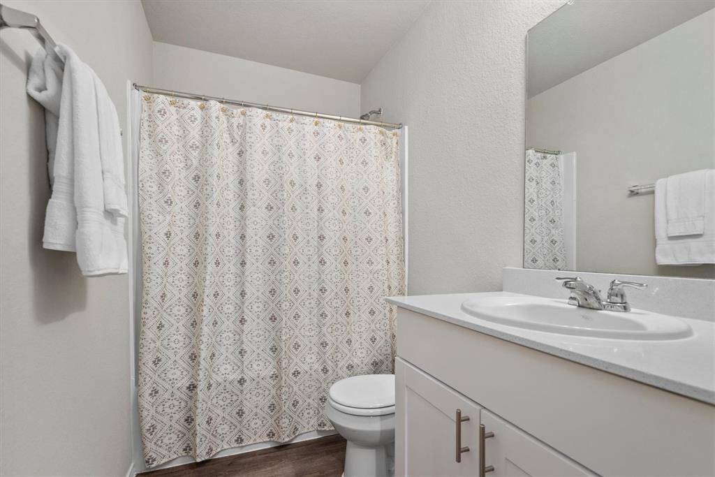 The secondary bathroom features a functional shower/tub combo.