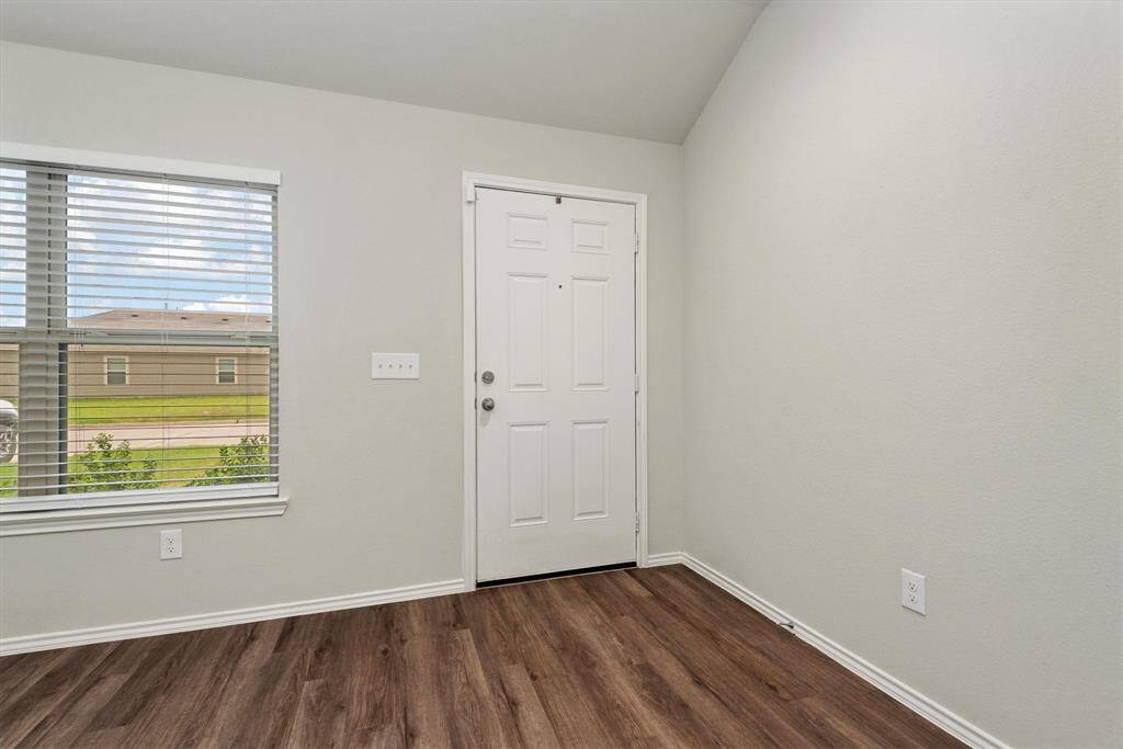 Entryway view featuring a welcoming foyer with natural light and a glimpse into the open area.