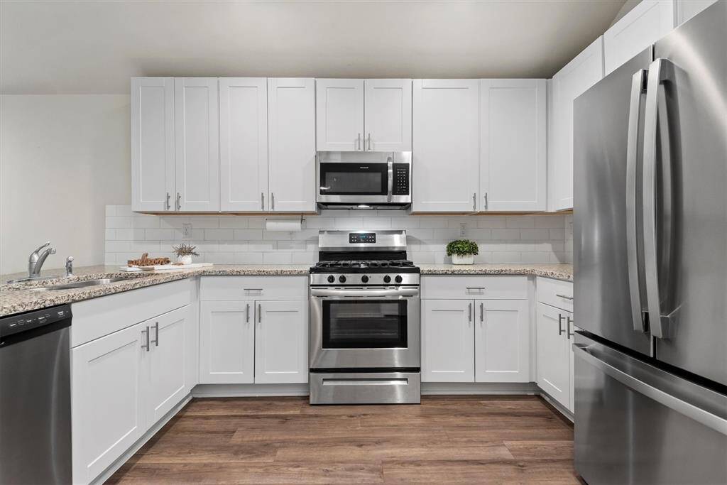 The kitchen blends functionality with warmth.  The white cabinets are stylish and offer ample storage space.