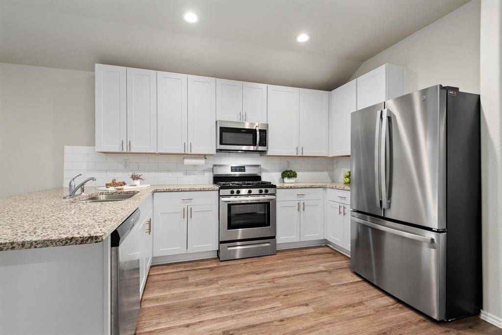 The kitchen boasts granite countertops and stainless steel appliances.