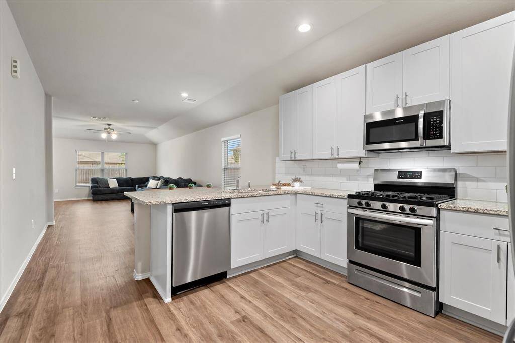 The open-concept layout connects the kitchen to the dining spaces and living area.