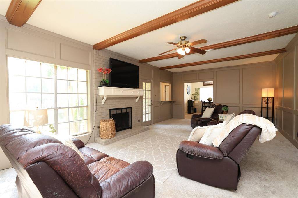 Fireplace is framed by windows looking out to back yard