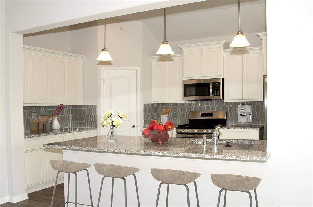 A chef's dream! Stylish backsplash, pendant lights and slide in gas range makes this kitchen a great space for entertaining family and friends.