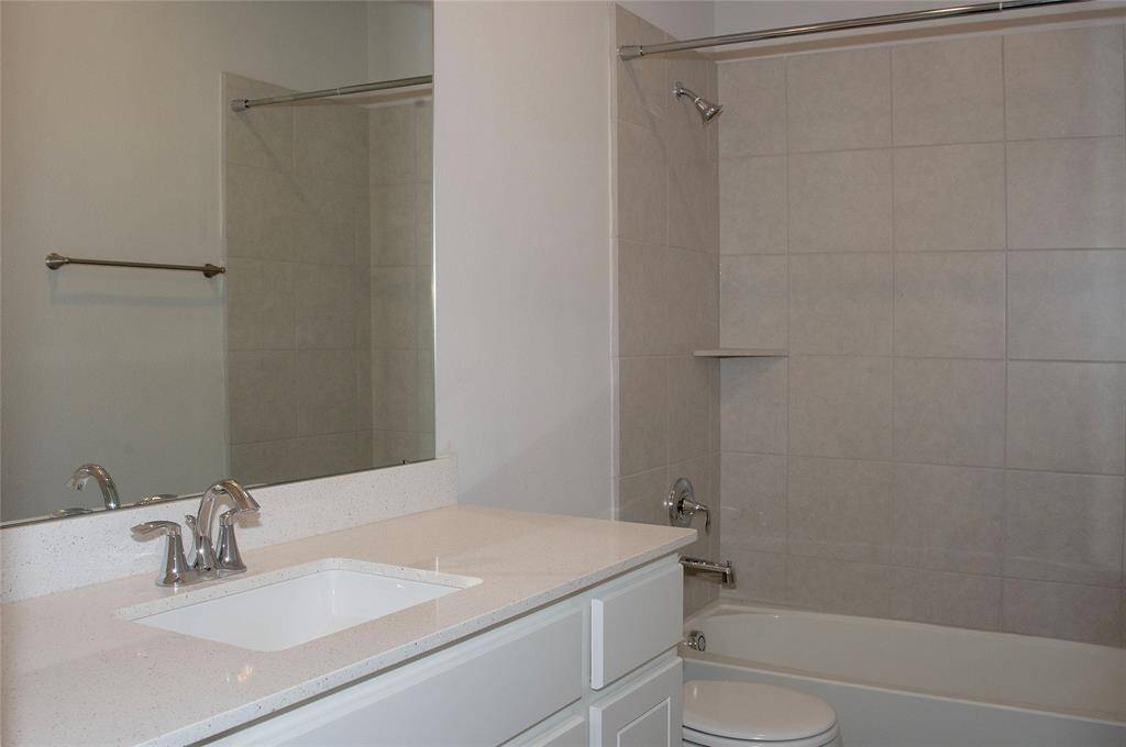 Bedroom 2 and 3 share this full bath.  Enjoy upgraded Tile shower surround and quartz surface counter.  1730 Cindy Lane.