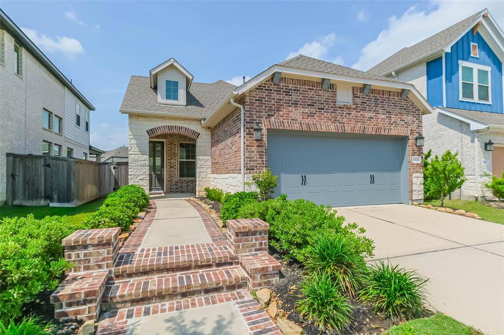 Welcome home! Guests will appreciate the private walkway accented by brick columns, and stone and brick archway leading to the covered front patio.