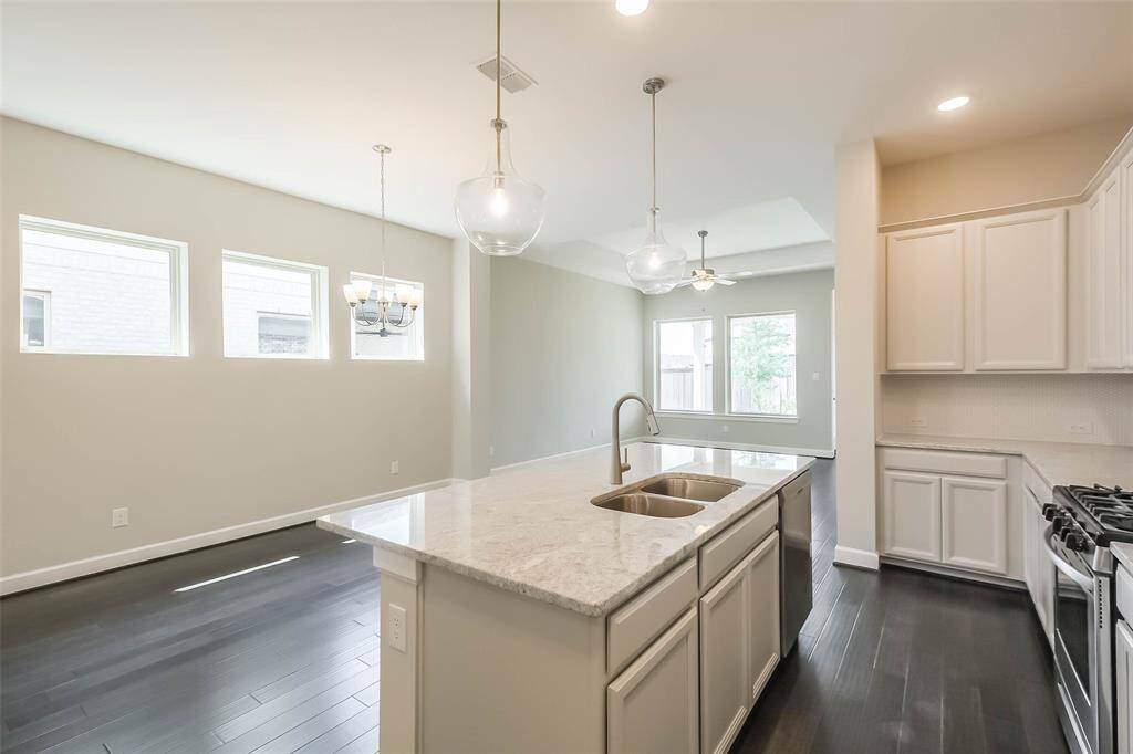 Another view of the kitchen features the chandelier at rear above the flexible dining/breakfast area.