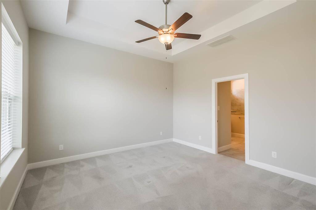 Primary bedroom features energy efficient ceiling fan, tray ceiling, abundant natural light and fully ensuite primary bath.