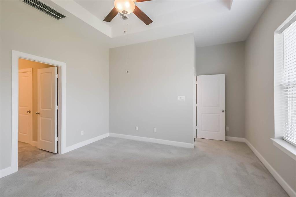 Another view of the primary bedroom, doorway on the right leads to the hall to the living area.