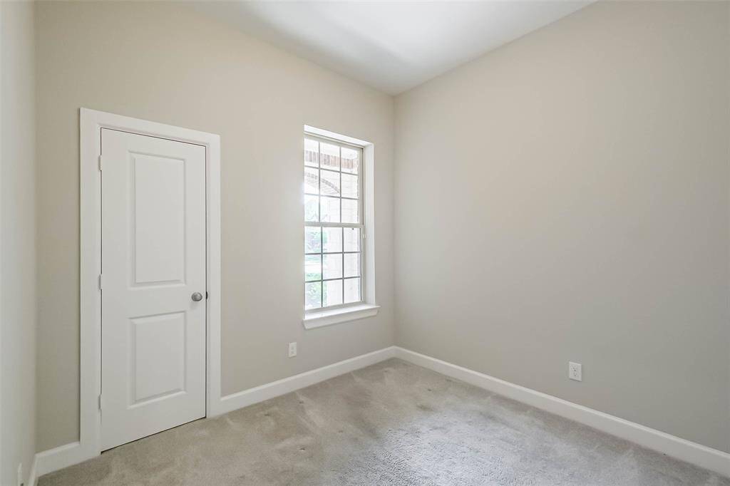 Guest bedroom 1. Covered front patio can be seen through the window.
