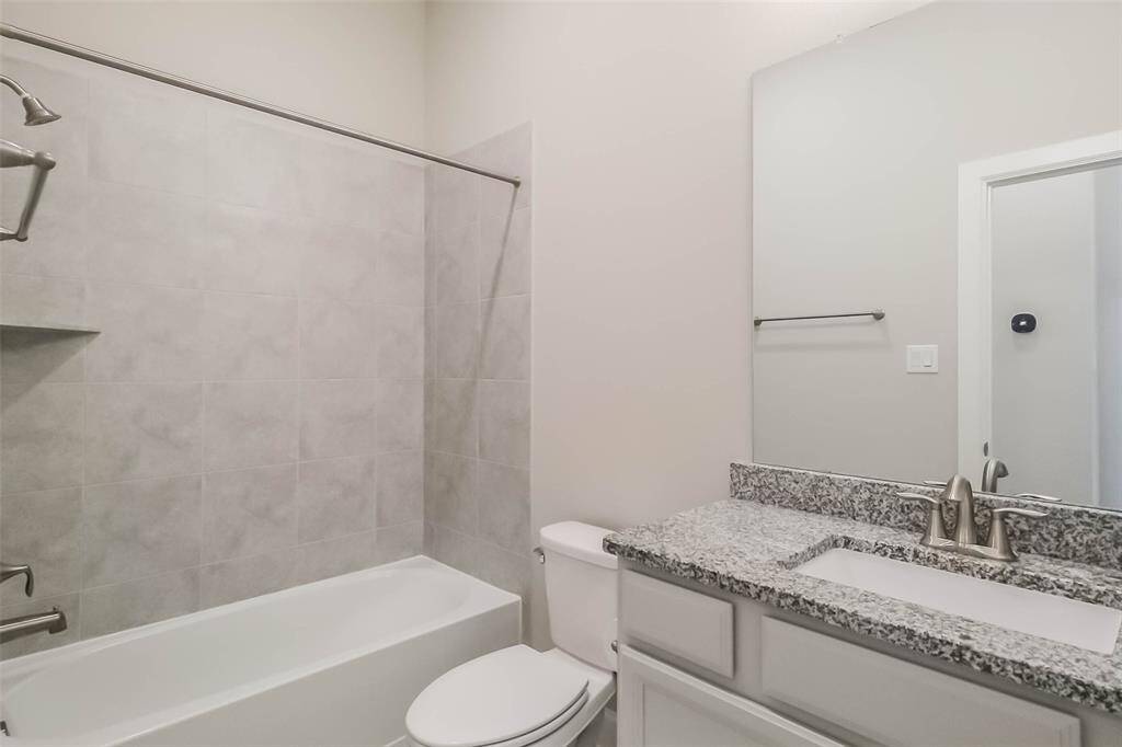 Secondary bathroom features granite countertop and high ceiling.