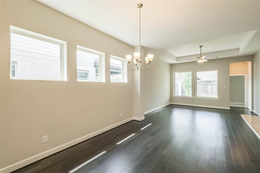 As you walk in past the front hallway, you're greeted with a spacious floor plan, wood floors, and plenty of natural light. Here you see the dining/living combination which is conveniently located adjacent to the kitchen on the right.