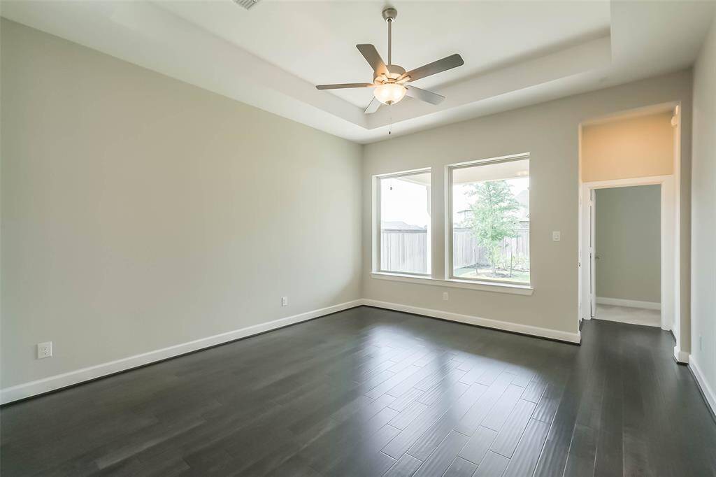 Living area has bright natural lighting, and ease of access to the covered rear patio. Doorway to the right is the entrance to the primary bedroom.